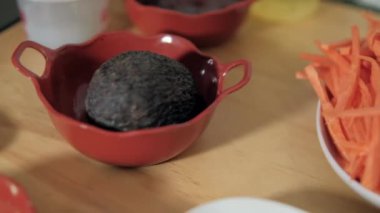 Masanın üstündeki çömlekte rendelenmiş yer elması ve avokado yığını.