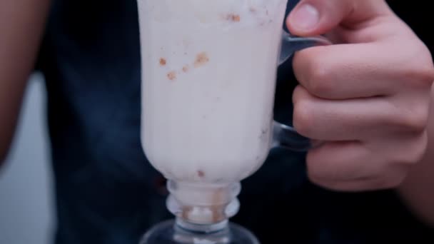 Mann hält und trinkt leckeren Vanille-Milchshake mit Stroh — Stockvideo