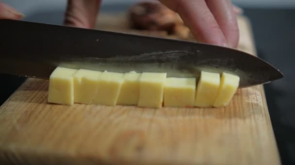 Kesme tahtasında taze Manchego peyniri doğrayan eller. — Stok video