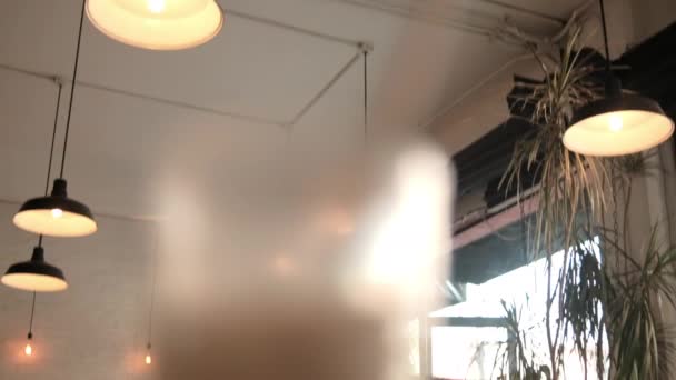 Milchshake mit Stroh im Glas über Holztisch — Stockvideo