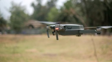 Arka planda bulanık ağaçlarla alçaktan uçan dron