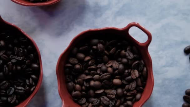 볶은 커피 원두 단지 세 개와 하얀 표면에 붙어 있는 별 모양의 씨 — 비디오