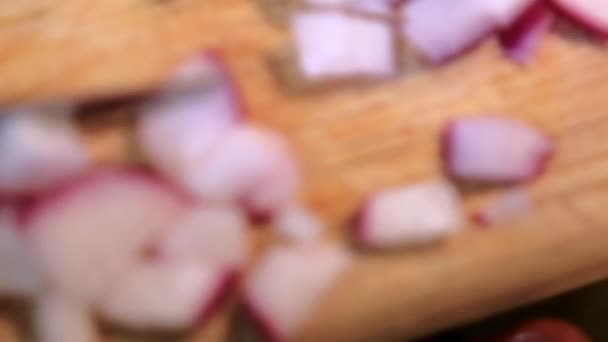 Verser les radis frais hachés dans une casserole d'argile — Video