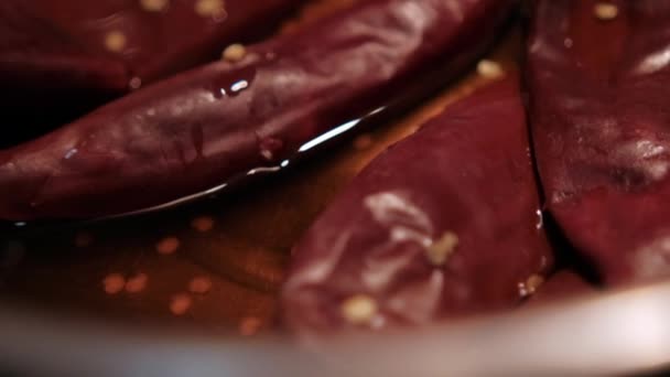 Poivrons rouges secs bouillant dans l'huile à l'intérieur de la casserole — Video