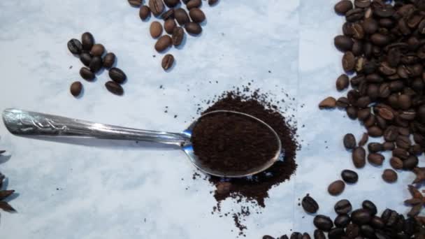 Cucchiaio di caffè circondato da mucchi di chicchi di caffè sulla superficie bianca — Video Stock