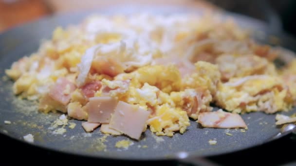 Äggröra med hackad kalkonskinka på ett runt stekbord — Stockvideo