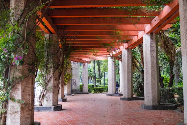 Corridor entouré de colonnes et sous pergola rouge dans le parc — Photo