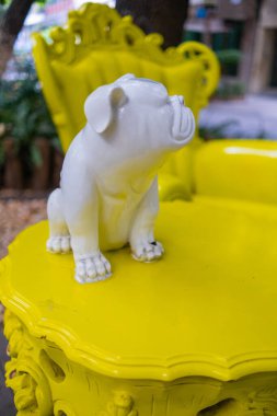 Beyaz bulldog heykelciği eski sarı masa ve parkta koltuk