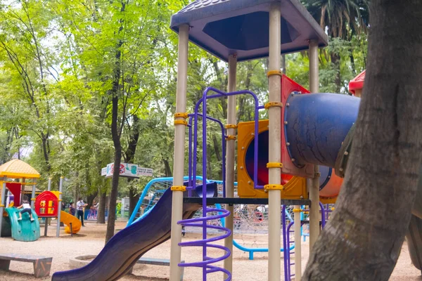 Kolorowa zjeżdżalnia na placu zabaw w środku parku — Zdjęcie stockowe