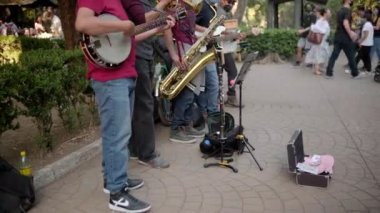 Beş müzisyen Mexico City 'den parkta neşeyle enstrüman çalıyor.