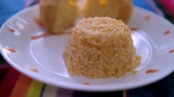 Autentyczne pyszny ryż meksykański i krojone danie chleba na kolorowy obrus — Wideo stockowe