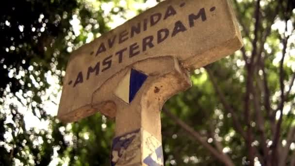 背景としてぼやけた木とアムステルダム通りの標識 — ストック動画