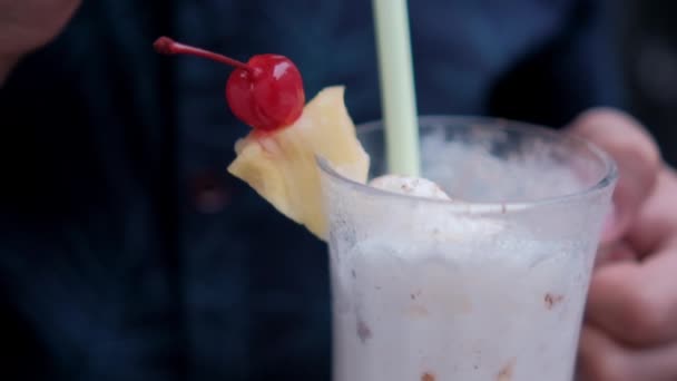 Homem segurando e bebendo saboroso milkshake de baunilha com palha — Vídeo de Stock