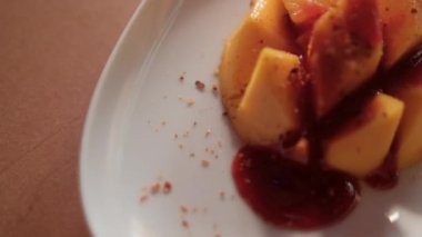 Meksika soslu ve bulanık arkaplanlı bir tabak doğranmış mango.