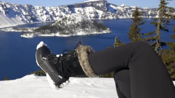 Piede femminile in scarpone da neve con montagne innevate e lago come sfondo — Video Stock