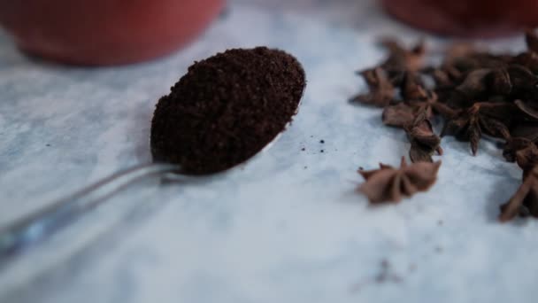 Ein Esslöffel Kaffee, umgeben von einem Haufen Sternaniskernen auf weißer Oberfläche — Stockvideo