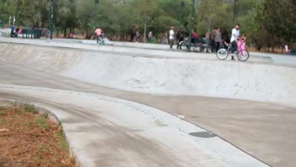 Vue en douceur du jeune homme faisant du vélo dans un skatepark — Video