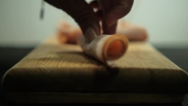 Handen snijden kalkoenbroodjes met tandenstokers boven snijplank — Stockvideo