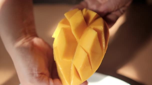 Hands holding diced mango above oval white plate — Stock Video