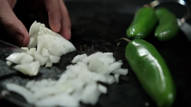 Handen hakken ui en groene chili pepers op een traditionele Mexicaanse comal — Stockvideo