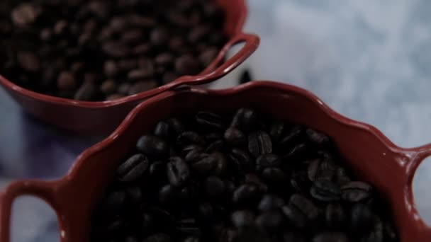 Три горшка жареных кофейных зерен и семена аниса на белой поверхности — стоковое видео
