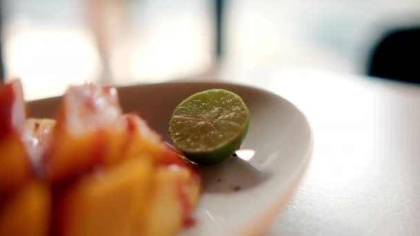 Teller mit gehackter Mango mit mexikanischer Gämsensoße und verschwommenem Hintergrund — Stockvideo