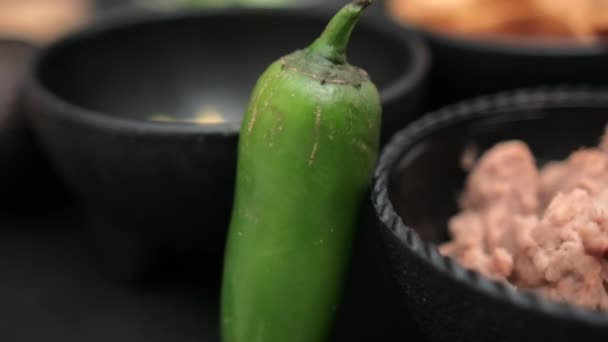 Chilli paprika opírající se o misky tortilla chipsů a smažených fazolí — Stock video