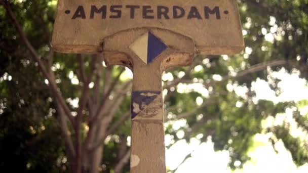 背景としてぼやけた木とアムステルダム通りの標識 — ストック動画