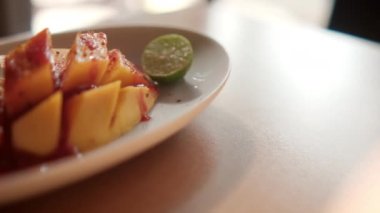 Meksika soslu ve bulanık arkaplanlı bir tabak doğranmış mango.