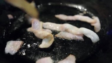 Kızartma tavasında ahşap kaşık ve kızgın yağ ile karıştırılmış pastırma