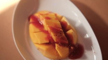 Meksika soslu ve bulanık arkaplanlı bir tabak doğranmış mango.