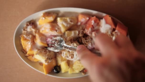 Tenedor pinchando rebanada de fruta con crema y avena en la parte superior — Vídeos de Stock