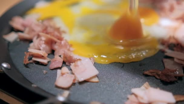 Jamón de pavo picado y dos yemas de huevo en una plancha redonda — Vídeos de Stock
