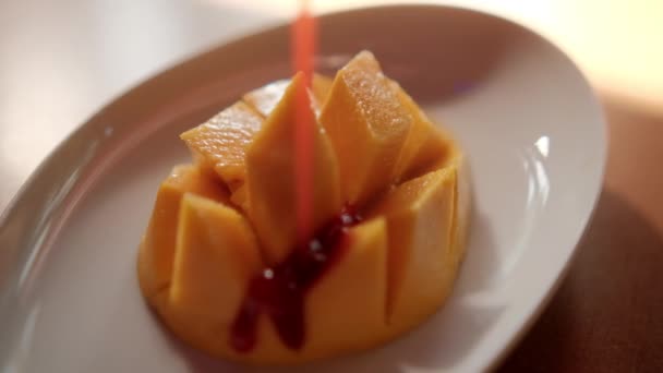 Nalać meksykańskiego szampana na posiekane mango na białym talerzu. — Wideo stockowe