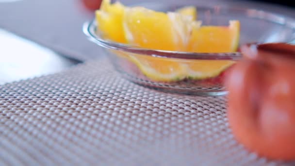 Fatias de laranja na placa de vidro acima no tapete de mesa cinza — Vídeo de Stock