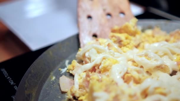 Spatula zbierając jajecznicę z siekaną szynką i topionym serem Oaxaca — Wideo stockowe