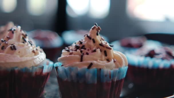 Leckere Cupcakes und Muffins mit Fenster als Hintergrund — Stockvideo