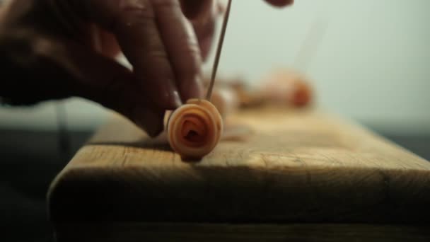 Händerna in tandpetare i kalkon skinka rullar ovanför skärbrädan — Stockvideo