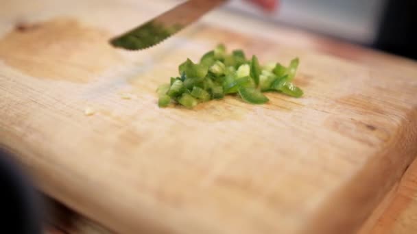 Mes langzaam duwen gehakte chili peper boven snijplank — Stockvideo