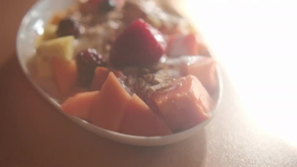 Plate of sliced fruit with cream and oatmeal on top — Stock Video