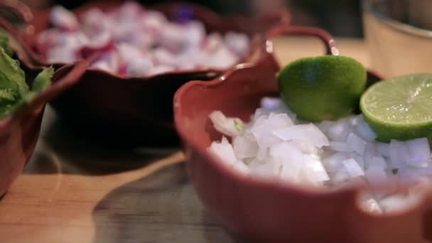 Macetas de arcilla de rábanos picados, cebollas, lechuga y limas sobre una mesa de madera — Vídeos de Stock