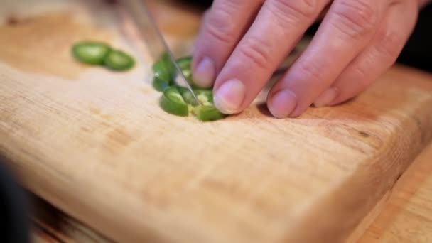 Hands slowly chopping chili pepper on cutting board — Stock Video
