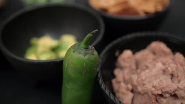 Chili lada bersandar pada mangkuk keripik tortilla dan kacang goreng — Stok Video