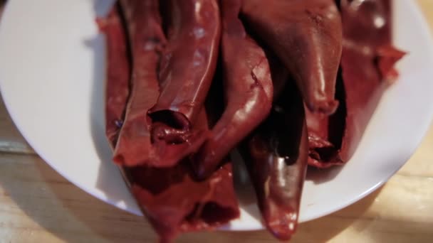 Sucha czerwona papryka chili na białym talerzu nad drewnianym stołem — Wideo stockowe