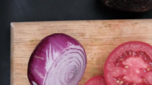 Cuencos de aguacate picado, lechuga y chips de tortilla en la superficie negra — Vídeo de stock