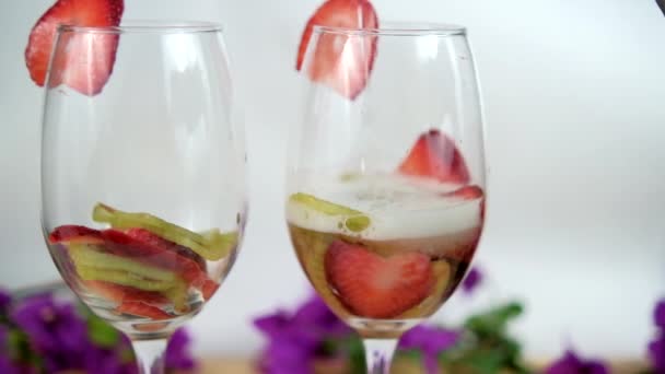 Kawałki truskawek i kiwi w kieliszkach do wina z białym tłem — Wideo stockowe