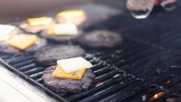 Kézzel spatula mozgó hamburger hús sajttal felett barbecue grill — Stock videók
