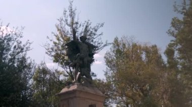 Arka planda ağaçlar olan güzel bir melek heykeli.