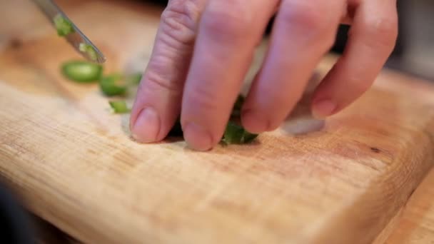 Hands slowly chopping chili pepper on cutting board — Stock Video