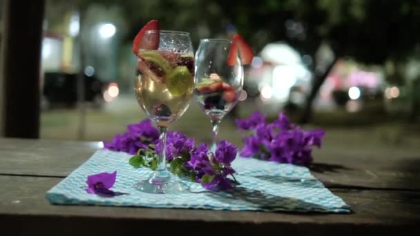 Twee drankjes met fruitschijfjes op geruite servet met wazige achtergrond — Stockvideo
